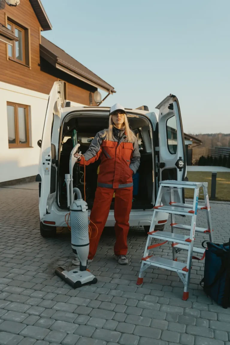 Home services marketing: house cleaner in coveralls beside a service van with a vacuum and a step ladder