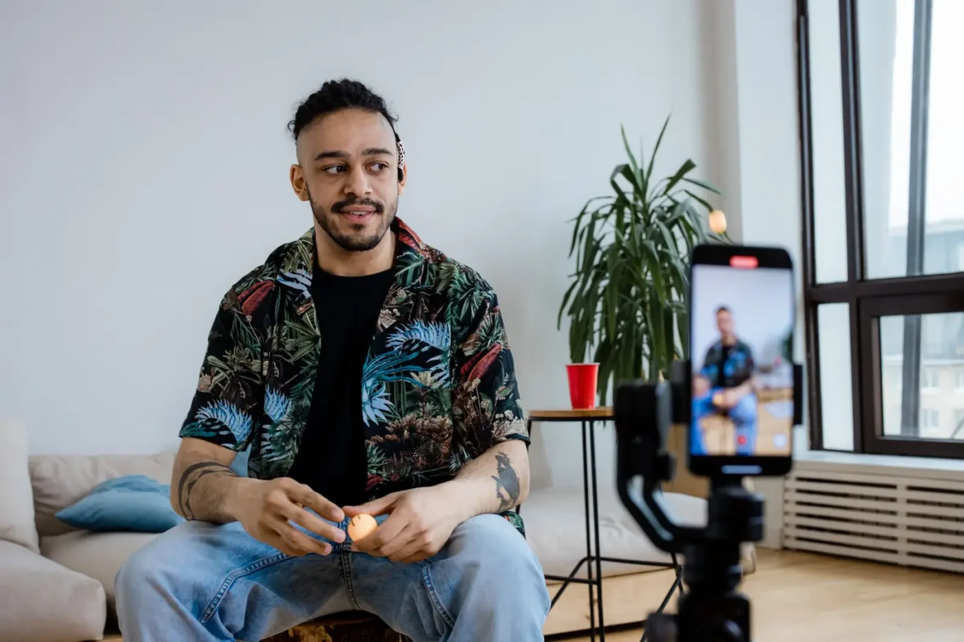 Social media marketing services: man recording a short video on a phone mounted on a tripod