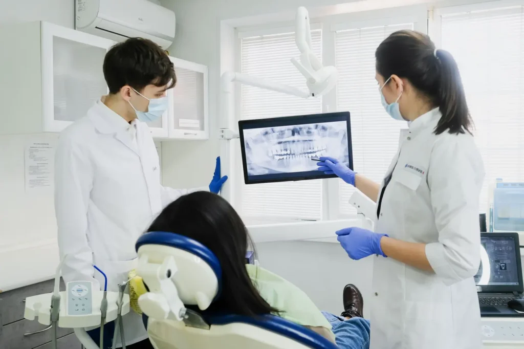 Dental team showing a patient her X-ray on a screen Dental SEO: dental team showing a patient her X-ray on a screen