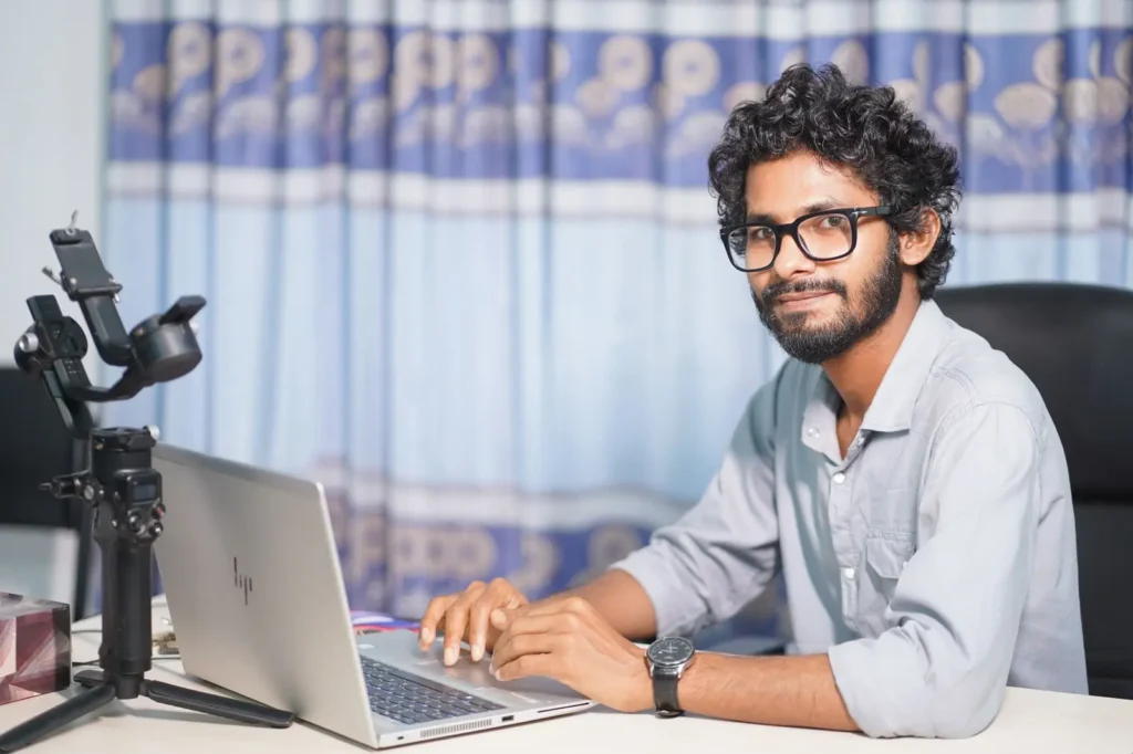 Web designer smiling while working on his laptop in a studio SEO for plumbers: web designer smiling while working on his laptop in a studio