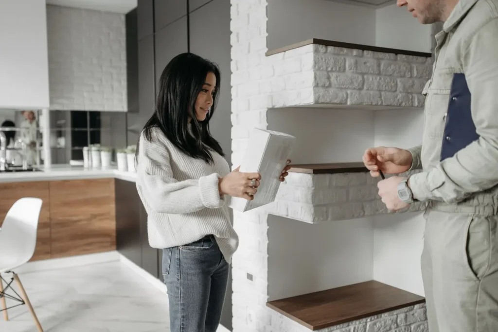 Local Services Ads management: homeowner holding a tablet while talking with a service technician in her kitchen