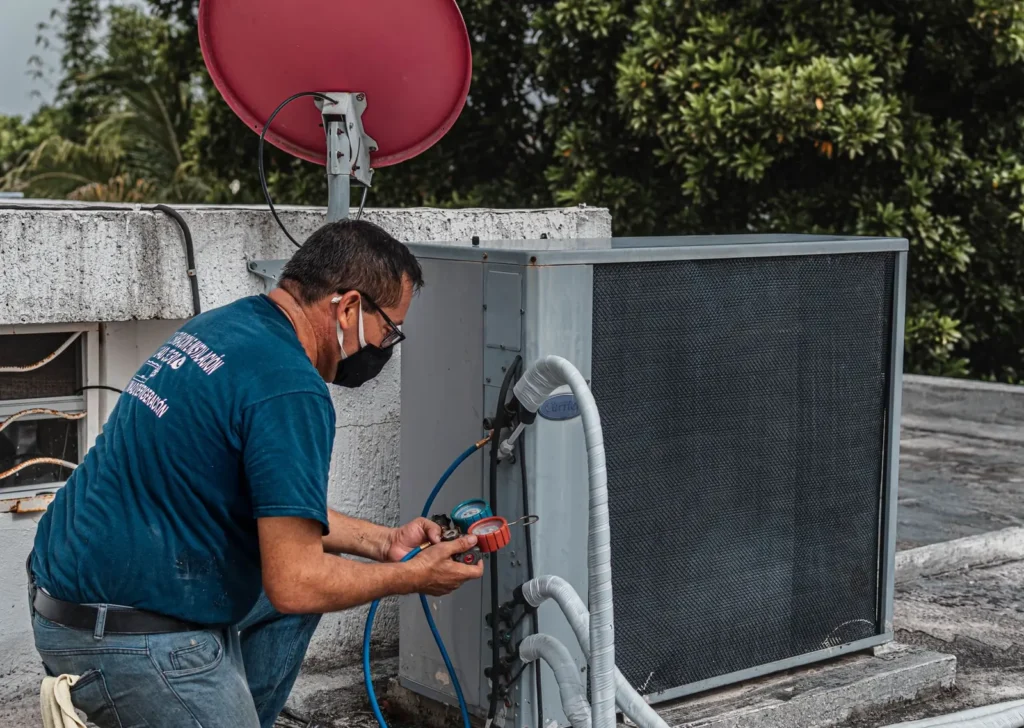 HVAC marketing: HVAC technician checking a rooftop air conditioning unit with refrigerant gauges