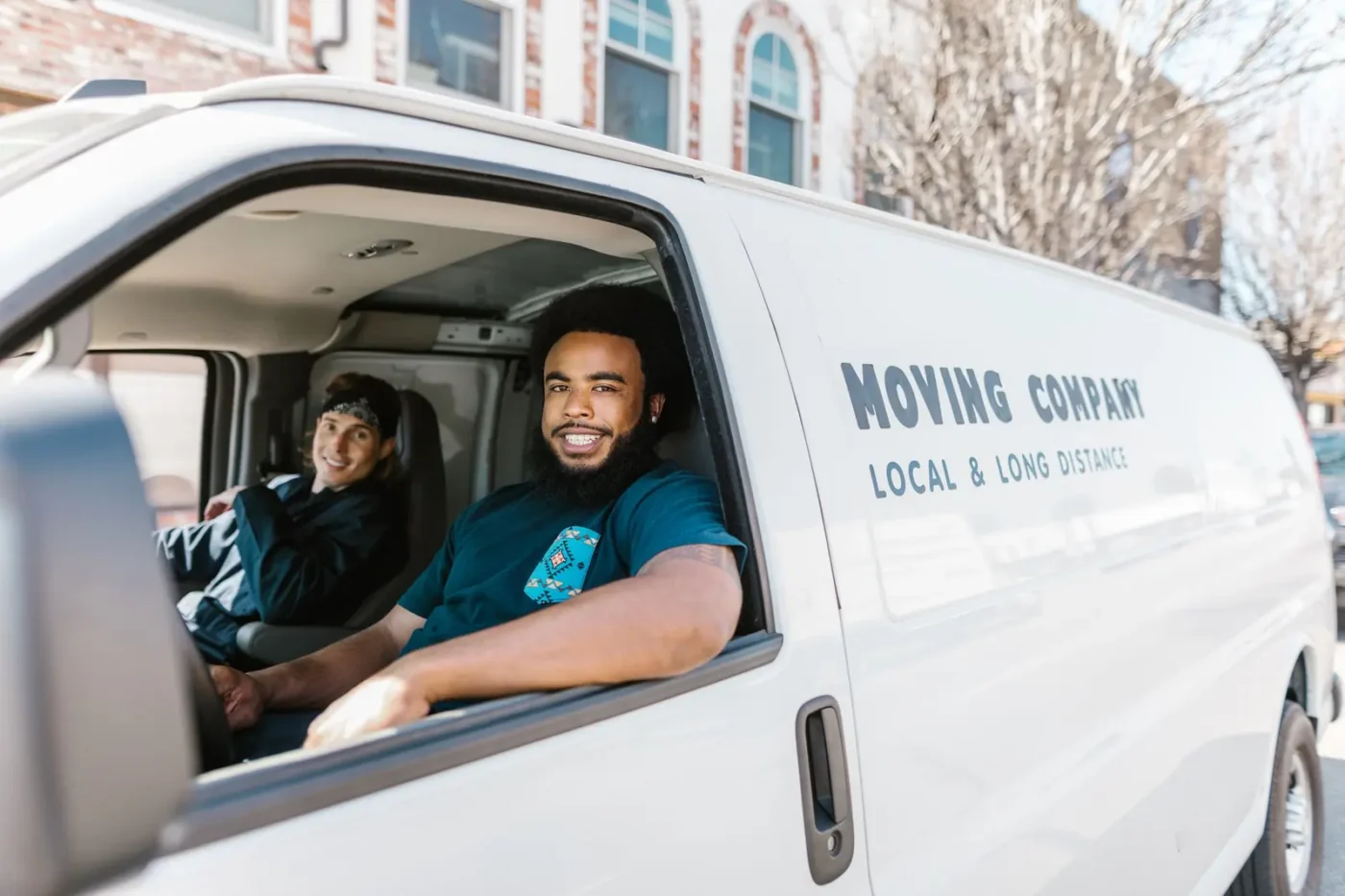 Moving company marketing: two movers smiling from a moving company van
