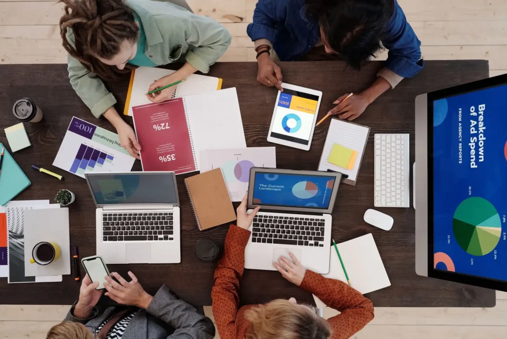 Overhead view of a team working through marketing reports Conversion rate optimization services: overhead view of a team working through marketing reports