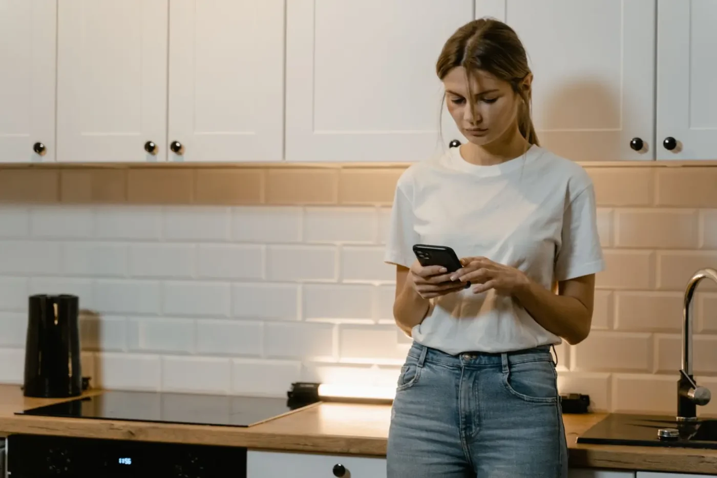 Local SEO services: woman searching on her phone in her kitchen