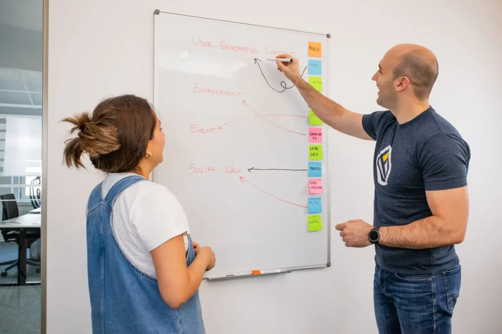 SEO services: two strategists mapping a plan on a whiteboard