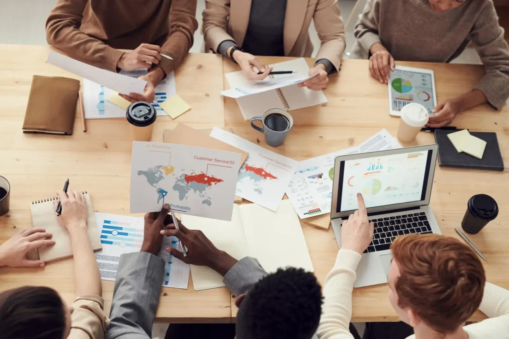 Overhead view of a team planning with charts, notes and laptops Digital marketing services: overhead view of a team planning with charts, notes and laptops