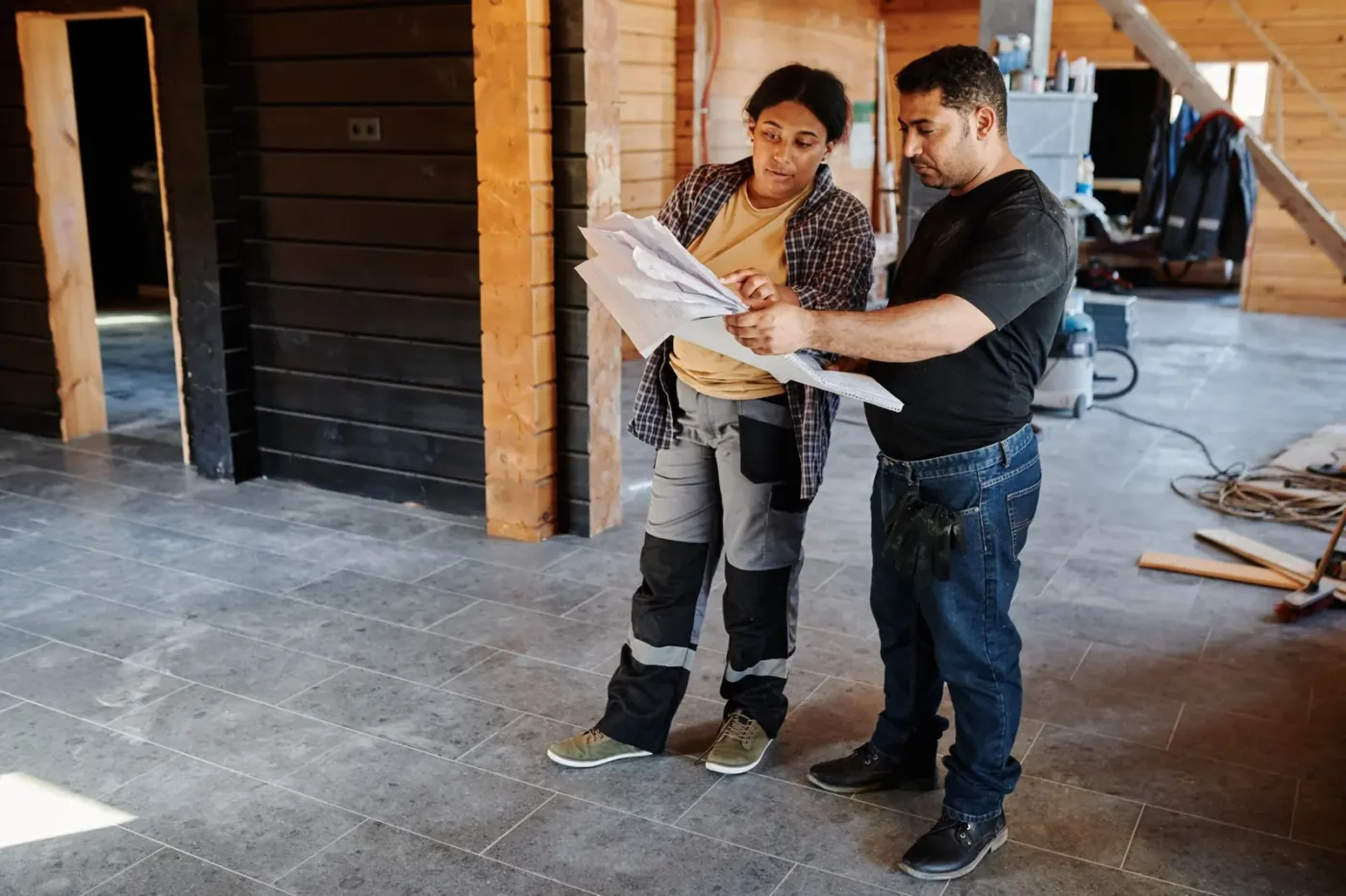 Contractors reviewing plans inside a home under renovation Remodeling marketing: contractors reviewing plans inside a home under renovation