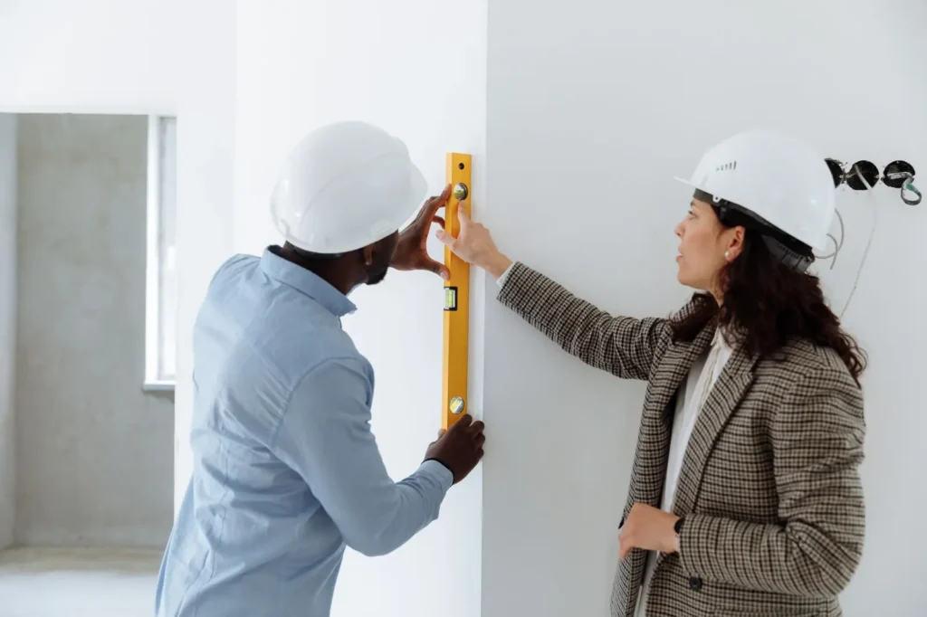 Contractors in hard hats checking a wall with a spirit level Remodeling marketing: contractors in hard hats checking a wall with a spirit level
