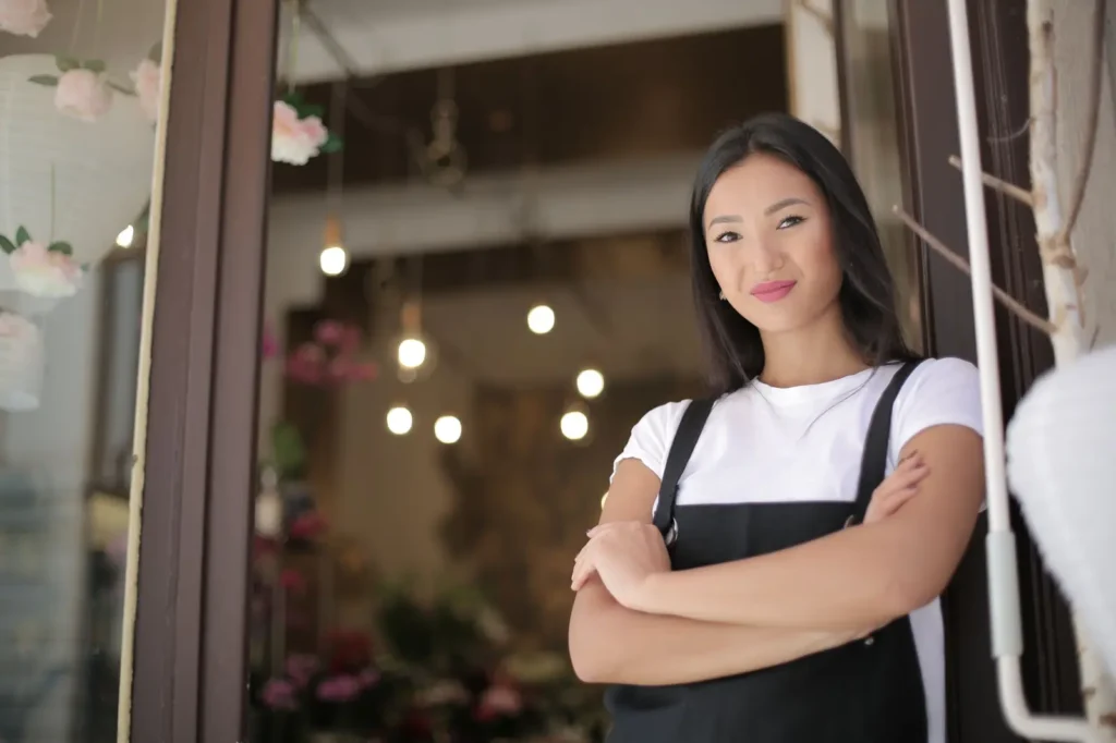 Shop owner standing at the entrance of her store Google Business Profile optimization: shop owner standing at the entrance of her store