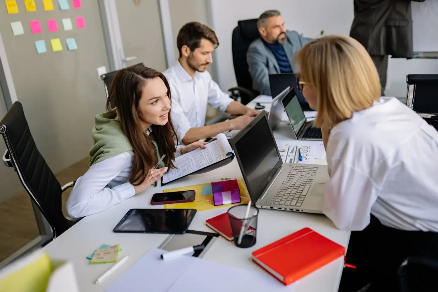 Team members comparing notes on laptops at a shared desk Digital marketing services: team members comparing notes on laptops at a shared desk