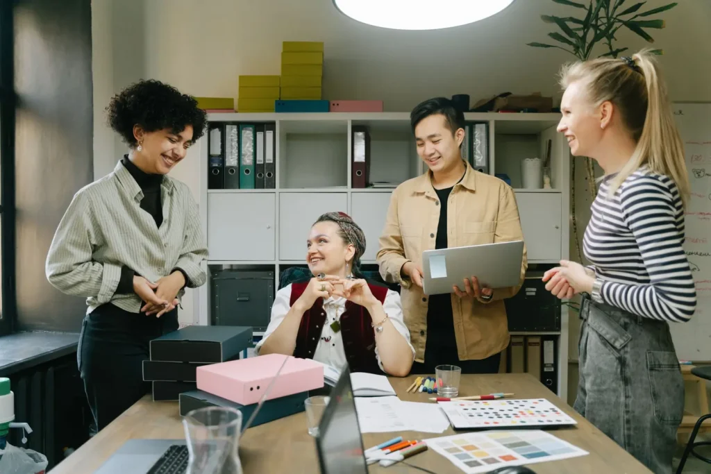 Digital marketing company: colleagues gathered around a desk reviewing work in a bright office